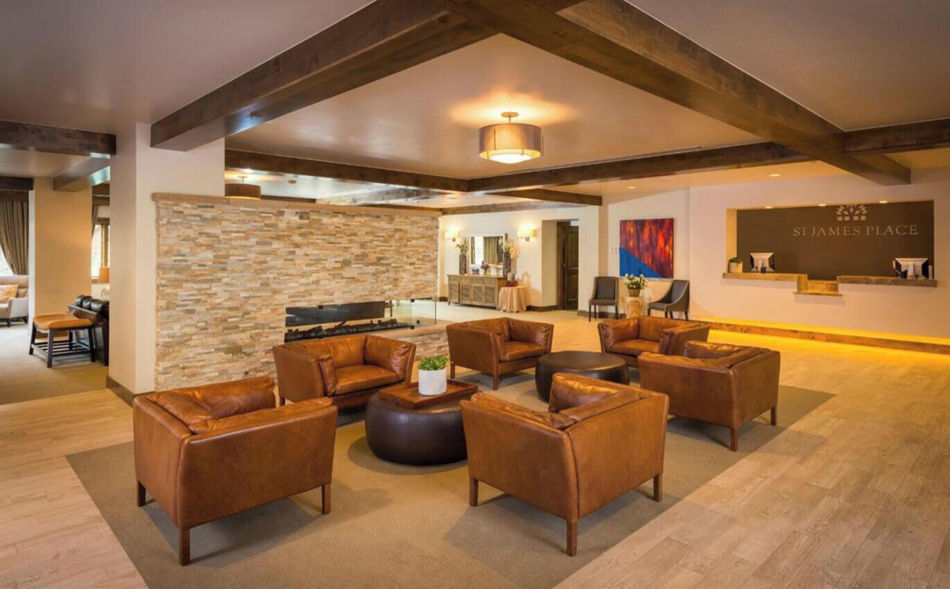A spacious lobby with leather sofas, a stone wall, and a reception desk labeled 'ST. JAMES PLACE'.