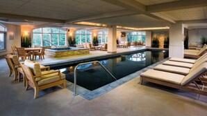Un espace piscine comprenant des chaises longues, un jacuzzi et des coins salon.