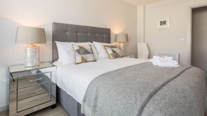 A bedroom with a bed, two bedside tables, lamps, a radiator, and a framed picture on the wall. - Large Modern Cottage, near the Medieval town of Athenry, Co Galway (North Athenry)
