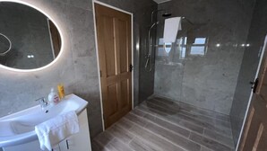 A modern bathroom with a large mirror, a sink, and a shower area. - Large Modern Cottage, near the Medieval town of Athenry, Co Galway (North Athenry)