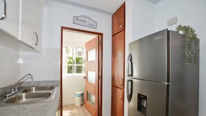 Eine Küche mit Edelstahlgeräten, einem Spülbecken und einer Tür zu einem Balkon.