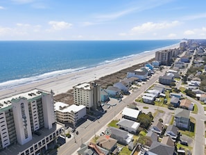 Eine Küstenstadt mit Strand, Wohnhäusern und einer Straße.