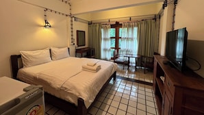 A hotel room with a bed, a desk, a television, and a window with curtains. - 403 Serene Teak Boutique Apartments (Chiang Mai)
