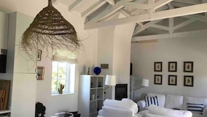 Um interior moderno com área de refeições, móveis brancos e um luminário tecido exclusivo.
