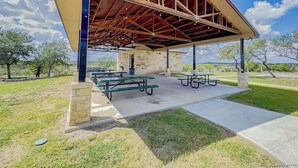 Un espacio cubierto para picnic con bancos y mesas.