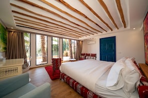 A bedroom with a large bed, a desk, a chair, and a view of the outdoors. - The House of Designers by BCKART GALLERY (Lalla Takarkoust)