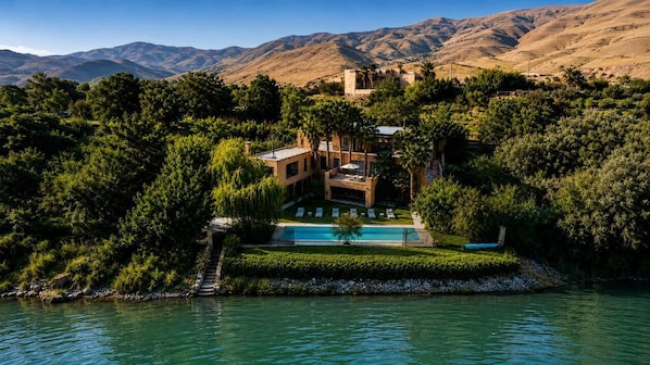 A resort with a pool, surrounded by lush greenery and mountains.