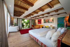 Una habitación de hotel moderna con una cama grande, un sofá, un escritorio y vistas al exterior.