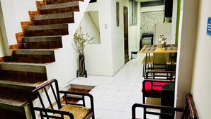 A staircase leading to a dining area with chairs and a table. - Apartahotel El Progreso (Armenia)