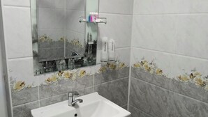 A bathroom with a white sink, a mirror, and floral-patterned tiles. - Gostevoy dom HOTEL ALLANAZAR OTA (Khiva)