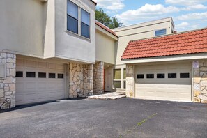 A residential property with two garages, stone exterior, and a red-tiled roof.