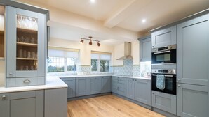 Una cucina con mobili grigi, forno integrato e una finestra vista.