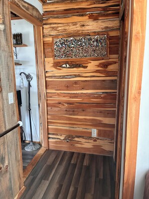 A wooden wall with a decorative mosaic panel and a floor lamp.