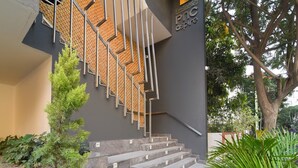 Un bâtiment moderne avec un escalier, un arbre et une enseigne sur laquelle on peut lire : « PNC aspire ».
