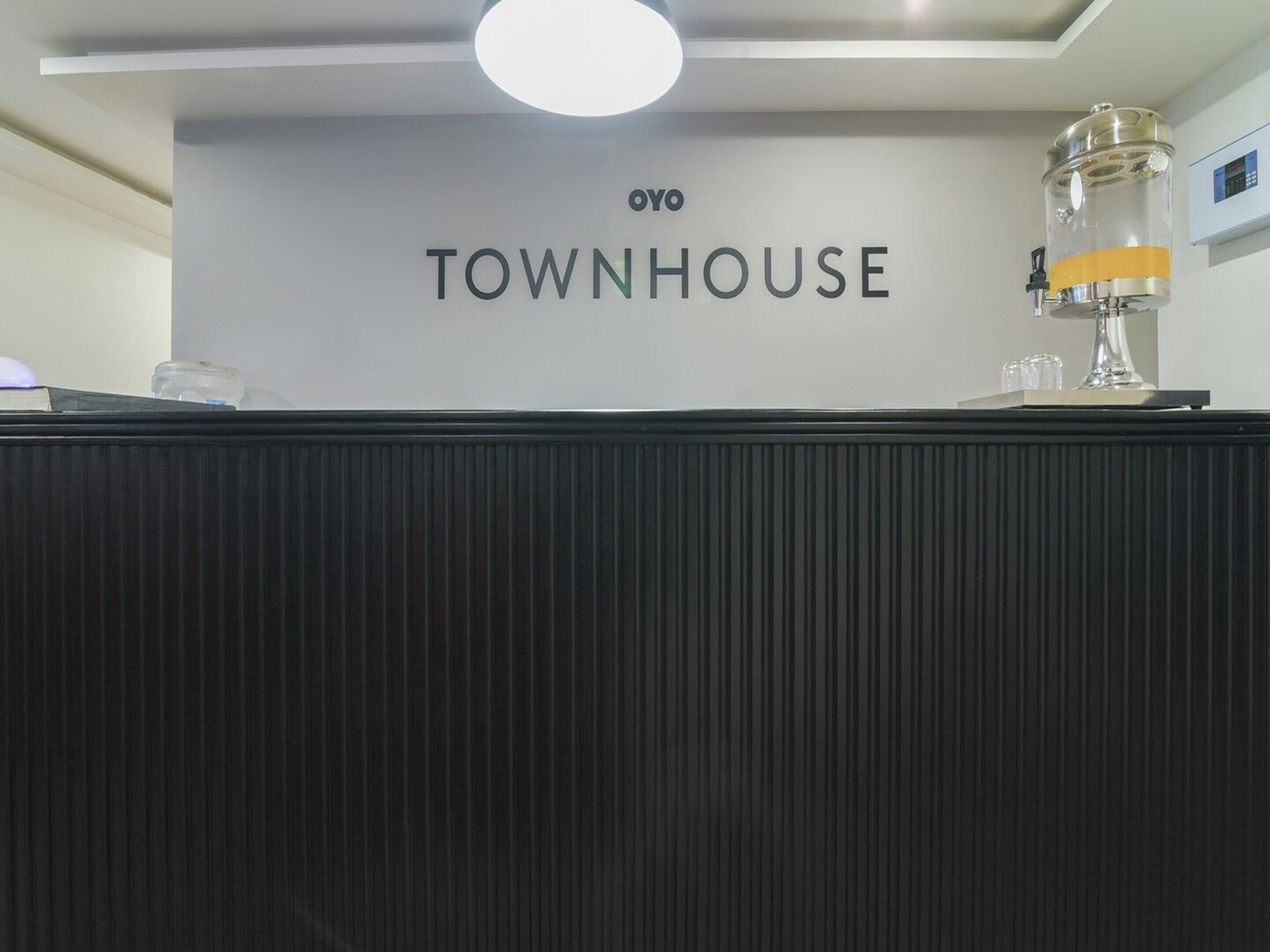 A reception desk with a sign that reads 'OYO TOWNHOUSE.'