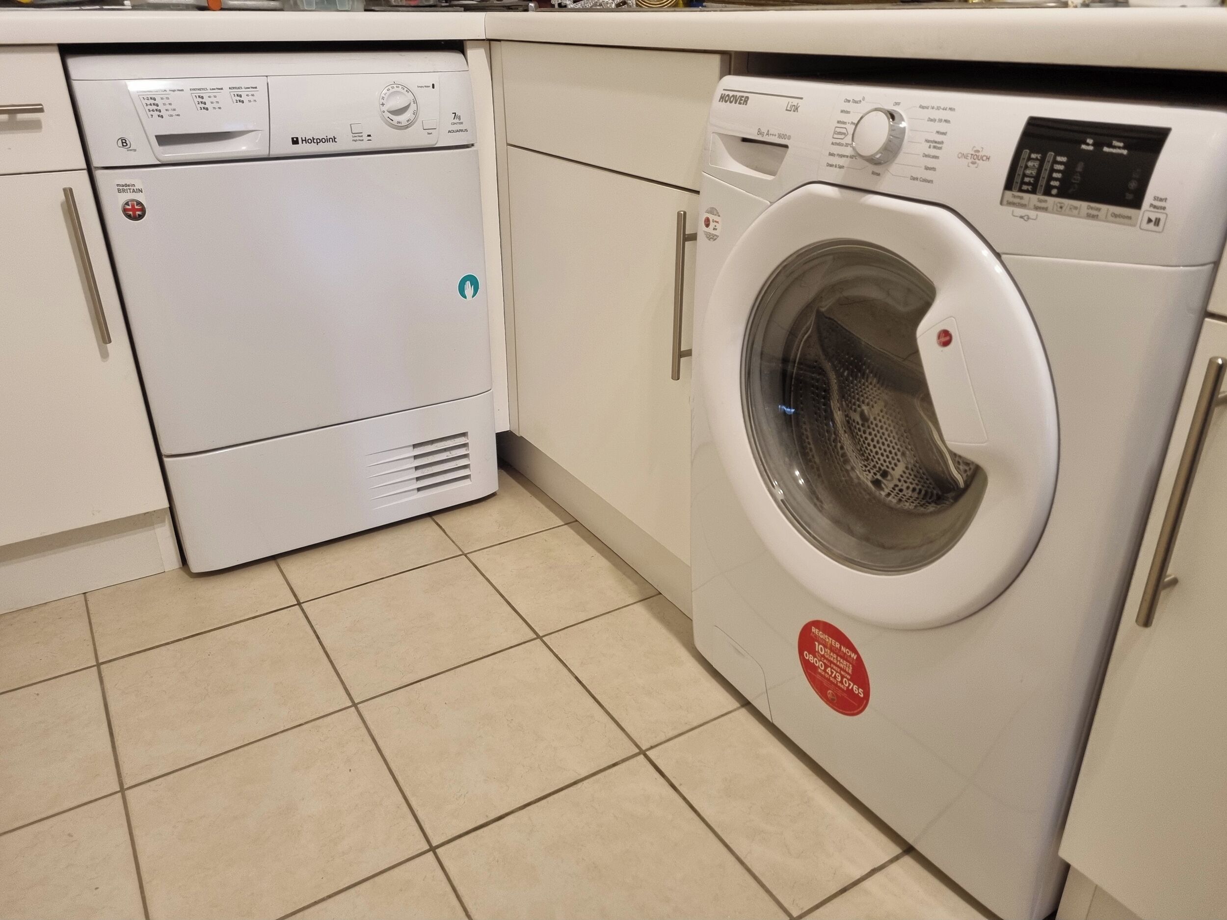 Cozinha compacta com máquina de lavar louça e máquina de lavar roupa frontal.