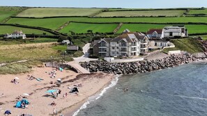 A coastal hotel with multiple buildings, a sandy beach, and a rocky shoreline. - 11 Thurlestone Rock (Kingsbridge)