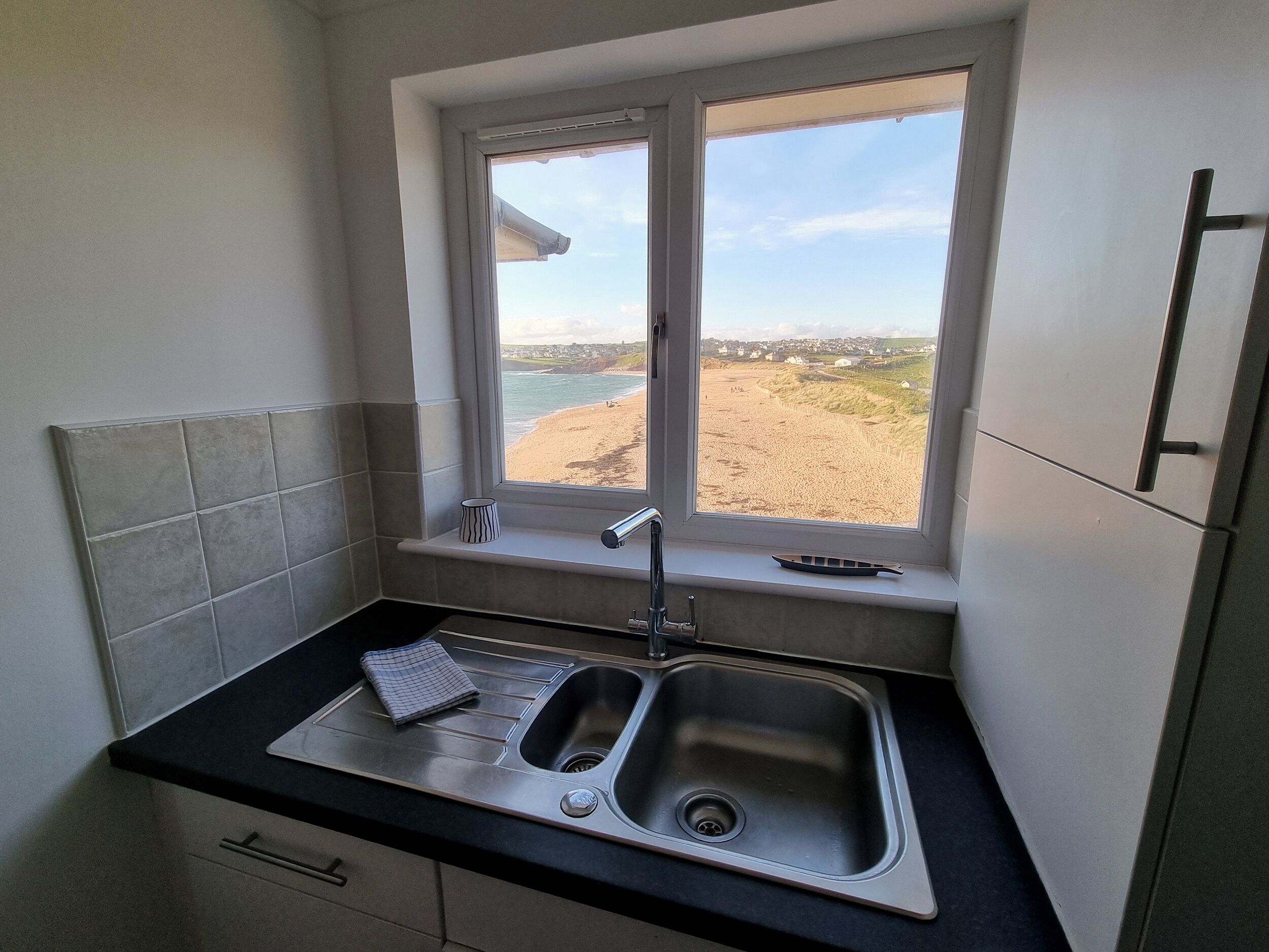 A kitchen with a window, a sink, and a towel.