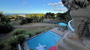A pool with a lion statue, a clear sky, and a view of the ocean. - Vieques BioBay B&B, The Palm Room: Sleep Under the Stars, Paddle the Glowing Bay (Vieques)