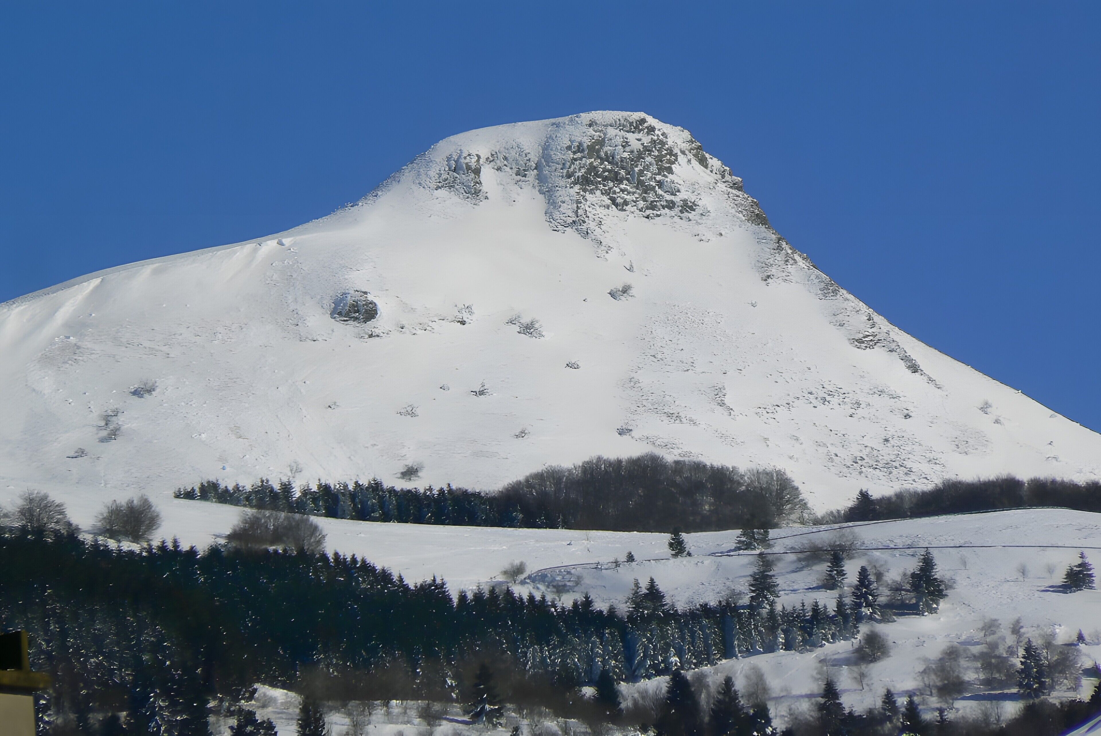 A snow-covered mountain with a clear blue sky.