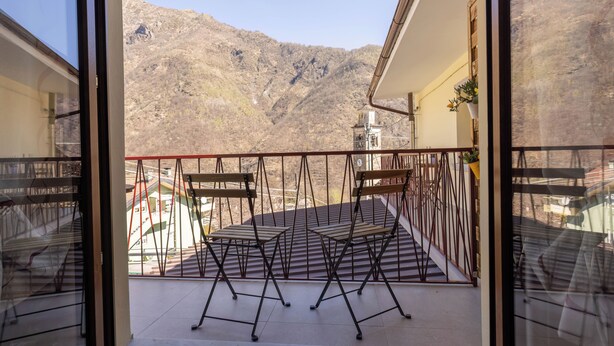 Ein Balkon mit Metallgeländern, einem Tisch und zwei Stühlen.