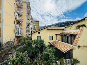 Zona residencial con edificios de varios pisos, un patio con vegetación y cielo despejado.