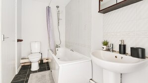 A bathroom with a toilet, bathtub, and sink. - Apartment Sleeps 5 With Garden (London)
