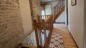 A wooden staircase with a handrail, a patterned rug, and a light fixture. - Apartment 'Gîte 1' with Shared Terrace, Shared Garden and Wi-Fi (Carentan-les-Marais)