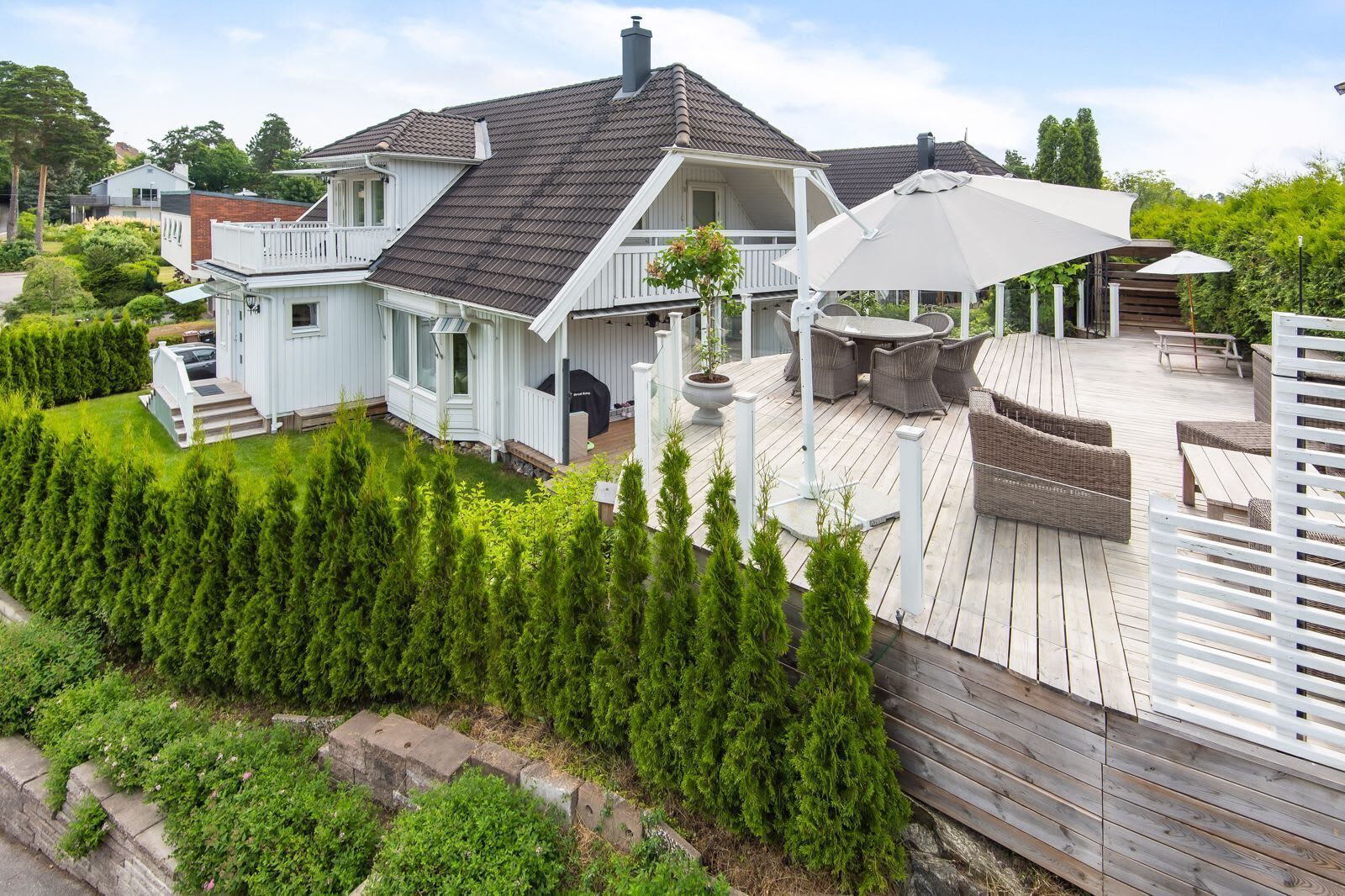Une maison dotée d’une terrasse, de mobilier d’extérieur et d’un patio couvert.