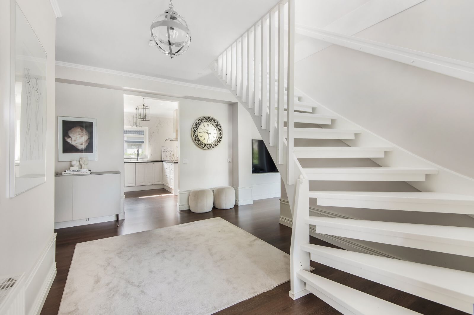 Un intérieur moderne comprenant un escalier, une cuisine et un coin repas.