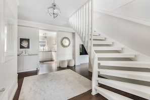Ein modernes Interieur mit Treppe, Küche und Essbereich.