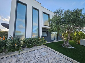 Un bâtiment moderne doté de grandes fenêtres, d’un chemin pavé et d’une pelouse bien entretenue.