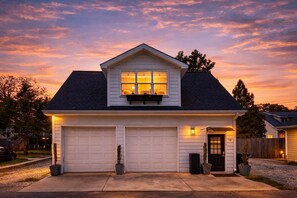 A two-story house with a garage, a front porch, and a mailbox.
