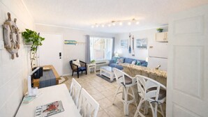 A compact living space with a dining area, a sofa, and a kitchen counter. - SandCastle - Entertainment District - Near Beach (South Padre Island)