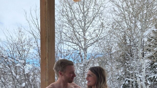 A couple in a hot tub with a snowy landscape in the background. - Luxury home with hot tub (Victor)