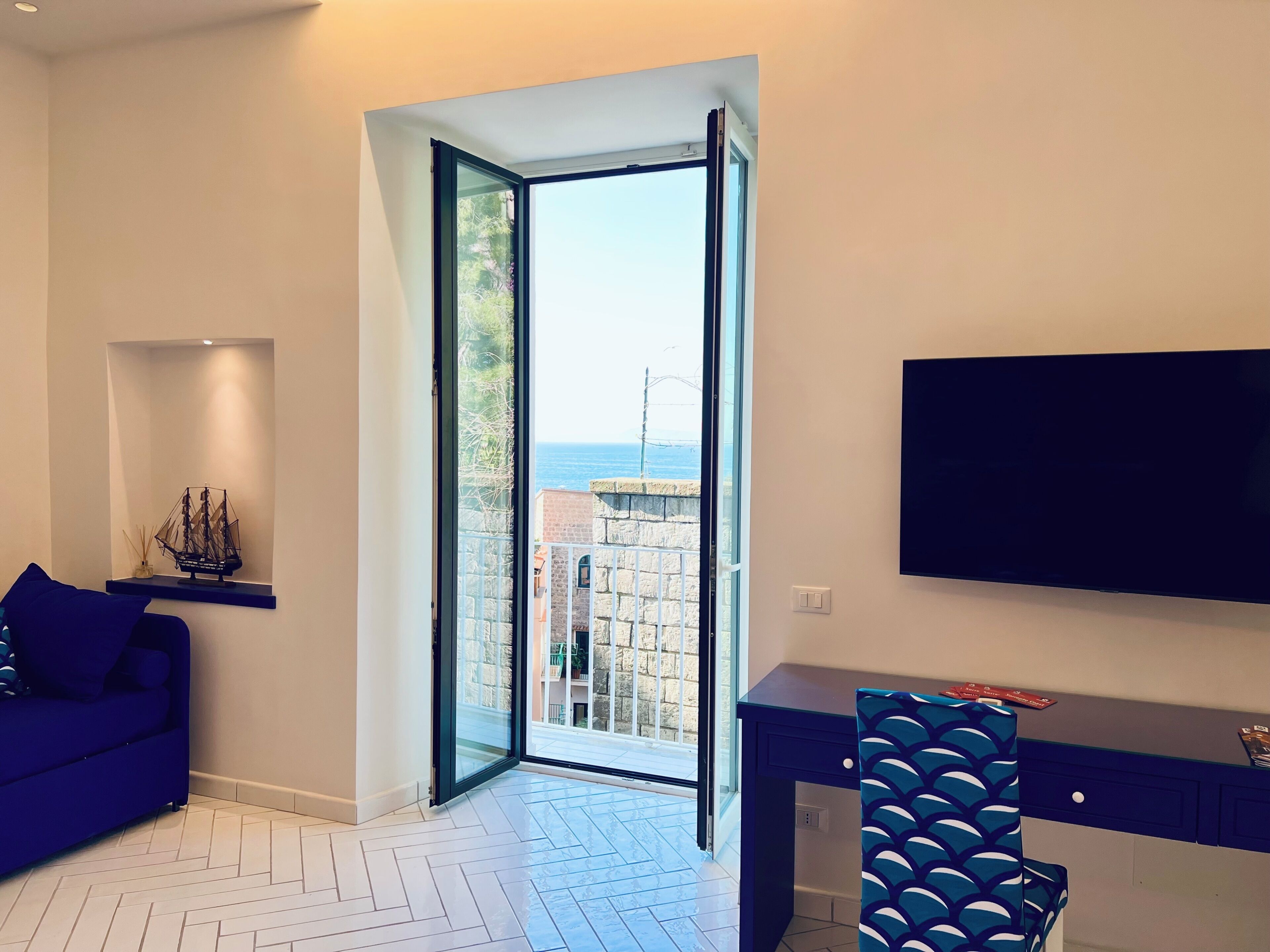 Appartement, balcon, vue partielle sur la mer | Coin séjour | Télévision à écran plat de 32 pouces avec chaînes numériques