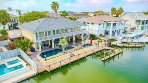 A waterfront property with a large pool, outdoor seating, and a dock. - Waterfront Retreat w/ Pool, Dock & Fire Pit (Rockport)