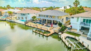 A waterfront property with a dock, a pool, and a covered patio area. - Waterfront Retreat w/ Pool, Dock & Fire Pit (Rockport)