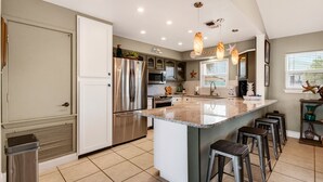 A modern kitchen with a central island, stainless steel appliances, and pendant lighting. - Waterfront Retreat w/ Pool, Dock & Fire Pit (Rockport)