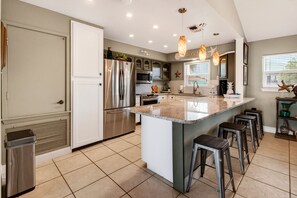 A modern kitchen with a central island, stainless steel appliances, and pendant lighting. - Waterfront Retreat w/ Pool, Dock & Fire Pit (Rockport)