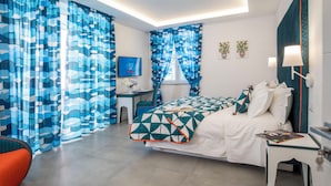 Ein modernes Hotelzimmer mit Bett, Schreibtisch, Stuhl und Vorhängen.