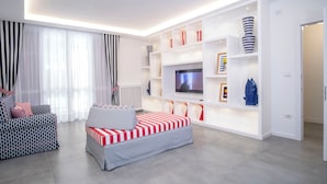 Ein modernes Wohnzimmer mit einer Couch, einem Fernseher und eingebauten Regalen mit Dekorationselementen.