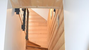 A wooden staircase with a handrail and a light switch on the wall. - Chalet for 10-12 Guests, 10 min from Peyragudes and Loudenvielle (Cazaux-Fréchet-Anéran-Camors)
