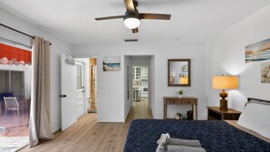 A hotel room with a bed, a ceiling fan, a desk, a lamp, and a view of the kitchen and dining area. - Just Renovated! Waterfront Oasis on the Intracoastal with Pool (Pompano Beach)