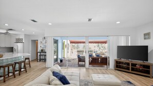 A modern living room with a sofa, ottoman, and a TV stand. - Just Renovated! Waterfront Oasis on the Intracoastal with Pool (Pompano Beach)