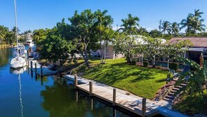 A marina with boats docked, a grassy area, and palm trees. - Just Renovated! Waterfront Oasis on the Intracoastal with Pool (Pompano Beach)