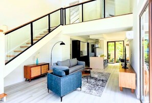 A spacious living area with a staircase, a sofa, a coffee table, and a wooden cabinet. - Private Chef Included | Oceanfront Villa | Pool & Beach (St. Mary Parish)