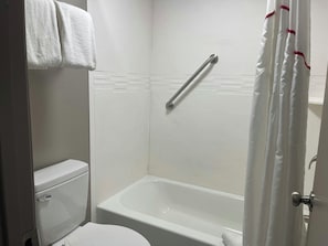 A bathroom with a white toilet, a bathtub, and a shower curtain. - Red Roof Inn Helen, GA - Downtown (Helen)