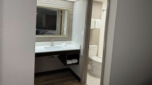 A bathroom with a white sink, a mirror, and a toilet. - Red Roof Inn Helen, GA - Downtown (Helen)
