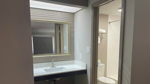 Un baño con lavabo, espejo y retrete.